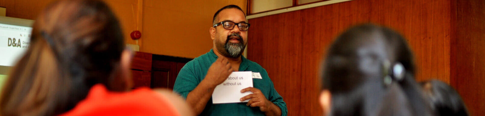 A photo of a man speaking in front of students.