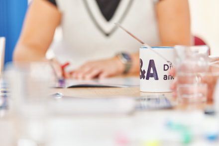 A table at a group training session with a D&A branded mug on.