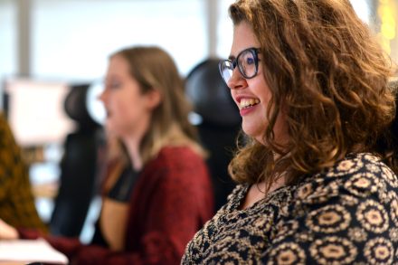 Two women working in an open plan office.