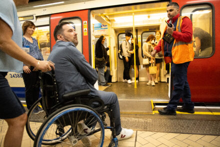 Adam a wheelchair user boards a train.