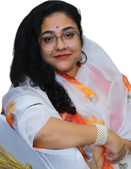 A south Asian woman wearing a white saree, glasses and a 'Bindi', as she smiles for the camera.